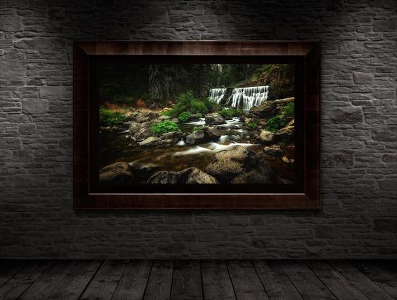 bathroom wall decor hanging on gray brick wall with dark ash frame and lining with photo of waterfall in it dark and moody